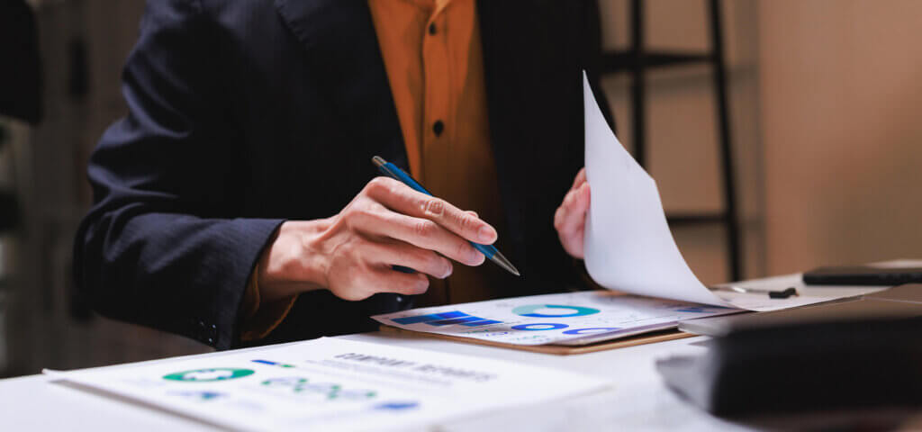 A PAC treasurer reviewing financial reports and charts at a desk

