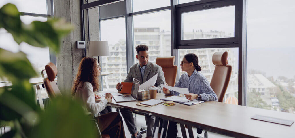 A small team of political committee staff reviewing compliance documents in a conference room